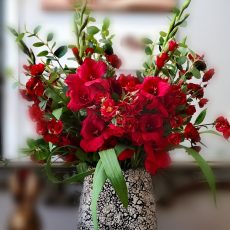 Mixed red display in black and white eggshell vase